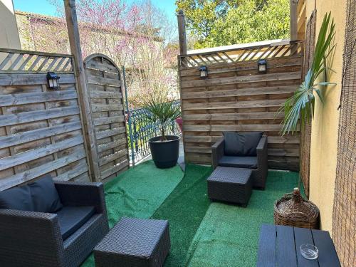 a patio with two chairs and a wooden fence at Logis Hôtel de France & Restaurant Pamiers in Pamiers