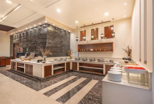 a large kitchen with a counter with food at Park Inn Gurgaon in Gurgaon