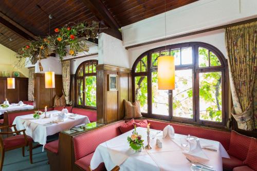 a restaurant with two tables and chairs and windows at Hotel Weinhaus Stern in Buergstadt