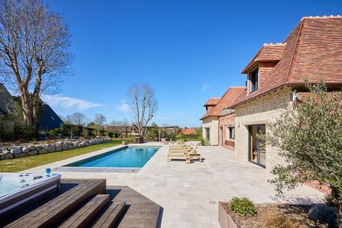 une piscine dans l'arrière-cour d'une maison dans l'établissement Villa les Roches Luxueuse Villa avec piscine 5 minutes de Deauville, à Touques