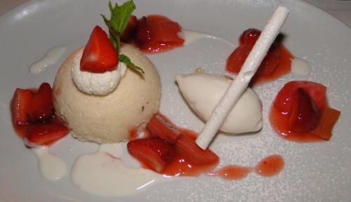 a dessert with strawberries and ice cream on a white plate at Hotel Weinhaus Stern in Buergstadt