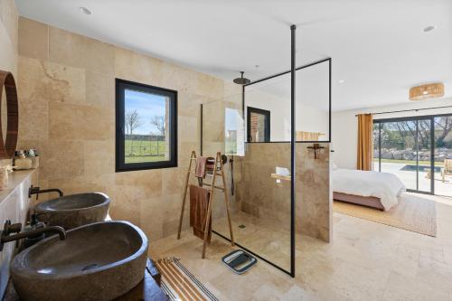 une salle de bain avec un lavabo et une douche et un lit dans l'établissement Villa les Roches Luxueuse Villa avec piscine 5 minutes de Deauville, à Touques