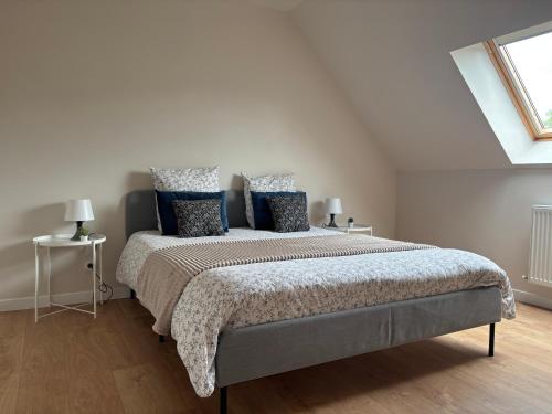 une chambre avec un grand lit avec des oreillers bleus dans l'établissement Maison cosy entre Paris Rouen et Deauville, à Pont-de-lʼArche