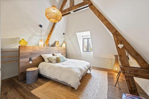 une chambre avec un grand lit dans un grenier dans l'établissement Villa les Roches Luxueuse Villa avec piscine 5 minutes de Deauville, à Touques