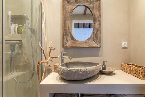 une salle de bain avec un lavabo en pierre et un miroir dans l'établissement Frejus, quiet villa, beautiful terrace and wifi, à Fréjus