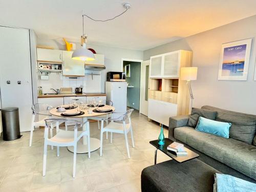 Il comprend un salon et une cuisine avec une table et un canapé. dans l'établissement Étel - Appartement Moderne 2 Pièces - WiFi - Animaux Bienvenus - Parking Privé - FR-1-479-210, à Étel