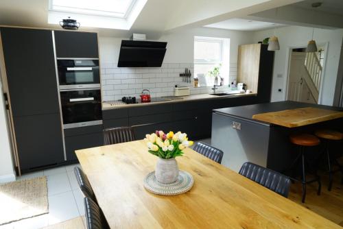 a kitchen with a wooden table with a vase of flowers on it at Oxford's cosiest 3 bedroom home with off street car parking in Oxford