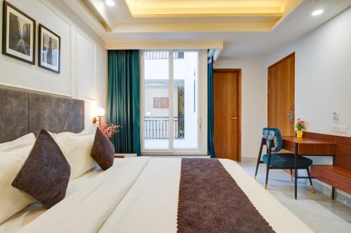 a hotel room with a bed and a desk and a window at Saltstayz Premier - Arjun Marg in Gurgaon