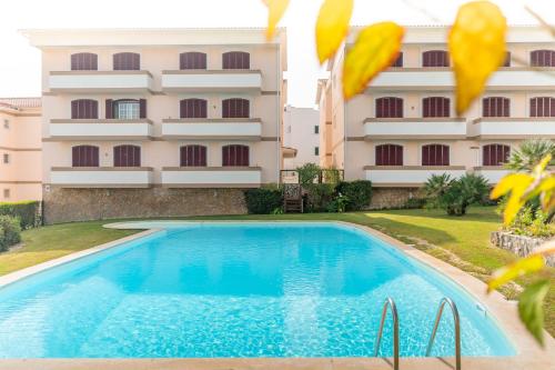 a swimming pool in front of a building at LV Premier Troia in Troia