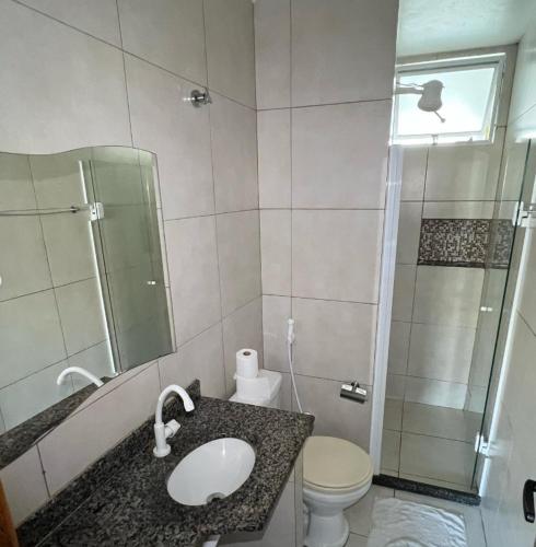 a bathroom with a sink and a shower and a toilet at Pousada Loft Praia dos Anjos in Arraial do Cabo