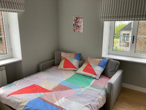 アヴランシュにあるJolie Maison avec piscine, proche Mt St Michelの窓2つが備わる客室で、ベッド1台(枕付)