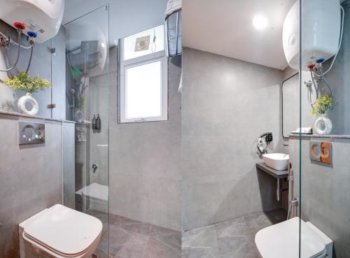 a bathroom with a shower and a toilet and a sink at Saltstayz Premier - Arjun Marg in Gurgaon