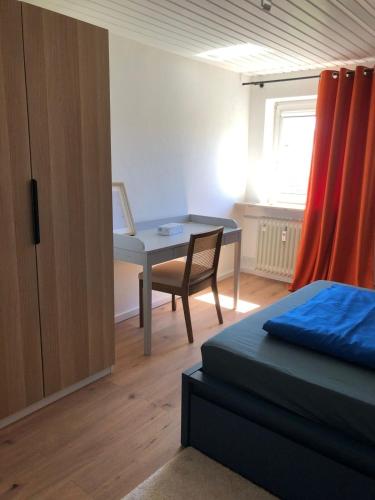 a bedroom with a desk and a bed and a table at Dachtraum in Vellmar