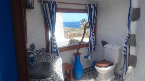 a bathroom with a toilet and a window with the ocean at Villa Exclusiva en El Hierro con Piscina Privada in Las Puntas