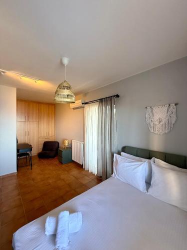 a bedroom with a white bed and a living room at Veranda Blue in Nikiana