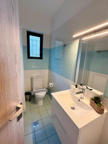 a bathroom with a white sink and a toilet at Veranda Blue in Nikiana