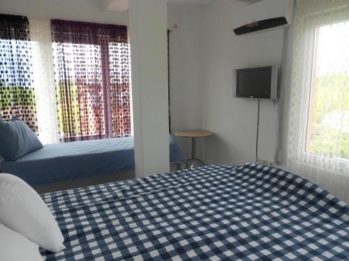 a bedroom with a bed and a tv and windows at Villa Angel Apartments - OHRID- in Ohrid