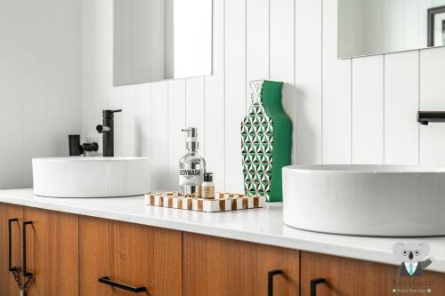 - Baño con 2 lavabos y botella de vino en Casa Del Vogue | Luxury | Lithgow Blue Mountain, en Lithgow