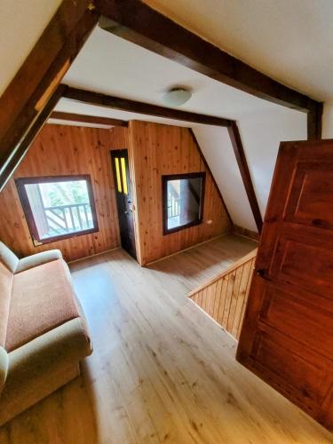 an attic room with a couch and a window at Domek Okonin in Elgiszewo