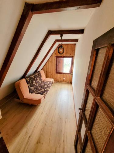 a attic room with a couch and a window at Domek Okonin in Elgiszewo