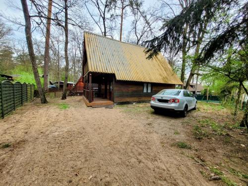a car parked in front of a small cabin at Domek Okonin in Elgiszewo