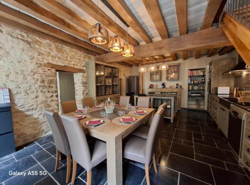 une cuisine et une salle à manger avec une table et des chaises en bois dans l'établissement Le Nid des Quais, à Decize