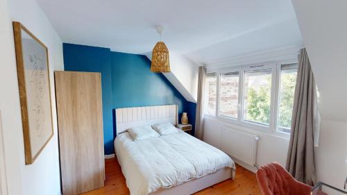a bedroom with a blue wall and a bed at Magnifique maison avec Jardin in Le Havre
