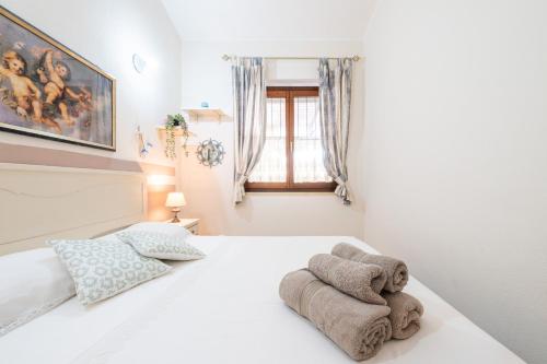 a bedroom with a white bed with towels on it at Casa Vacanze Claudia in Costa Rei