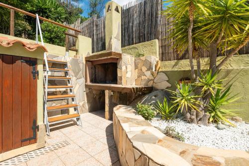 a patio with a wooden door and a staircase in a yard at Casa Vacanze Claudia in Costa Rei