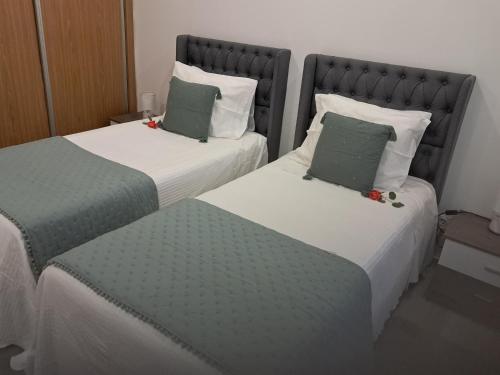 two beds in a room with green and white at My home in Cercal