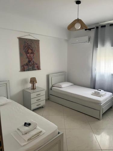 a bedroom with two beds and a painting on the wall at marialena villa in Skala Potamias