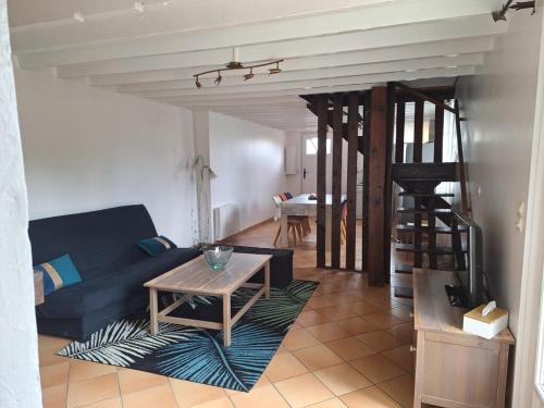 a living room with a blue couch and a table at L'Auberge de la fontaine in Fontaine-sous-Jouy