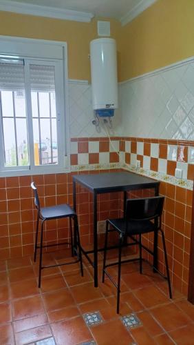 a kitchen with a table and two chairs in a room at Luz de Ardales in Ardales