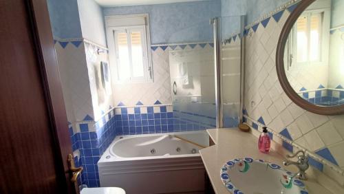 a blue and white bathroom with a tub and a mirror at Luz de Ardales in Ardales