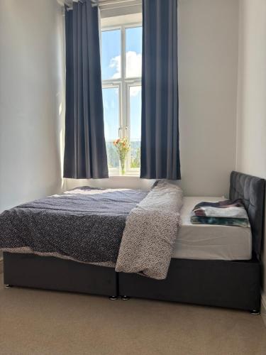 a bed in a bedroom with a window at Borehamwood Apartment in Borehamwood