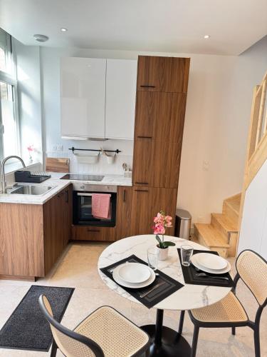 une cuisine et une salle à manger avec une table et des chaises dans l'établissement Luxueux logement proche gare et centre ville, à Tourcoing