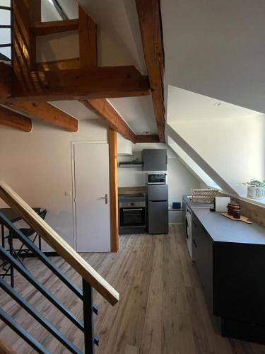 une cuisine avec un escalier menant à une mezzanine dans l'établissement Le Dolois, à Dole