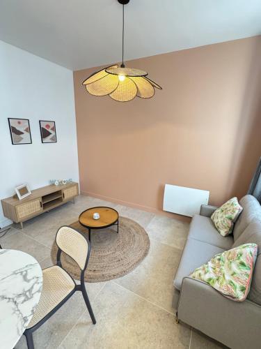 ein Wohnzimmer mit Sofa und Tisch in der Unterkunft Luxueux logement proche gare et centre ville in Tourcoing