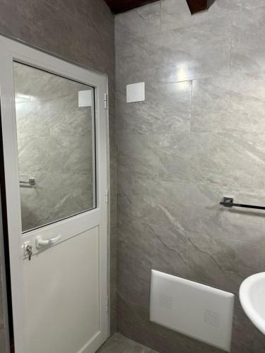a bathroom with a shower and a sink and a door at Villa Zefi Rrencc in Shkodër