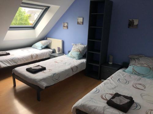 une chambre avec deux lits et une fenêtre dans l'établissement Chez Christophe et Cécile sur le circuit des 24 heures du Mans, à Arnage