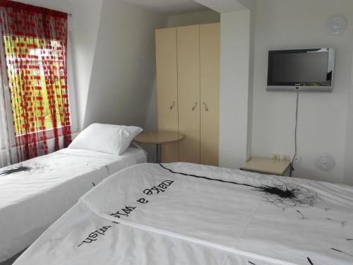 two beds in a room with a tv on the wall at Villa Angel Apartments - OHRID- in Ohrid