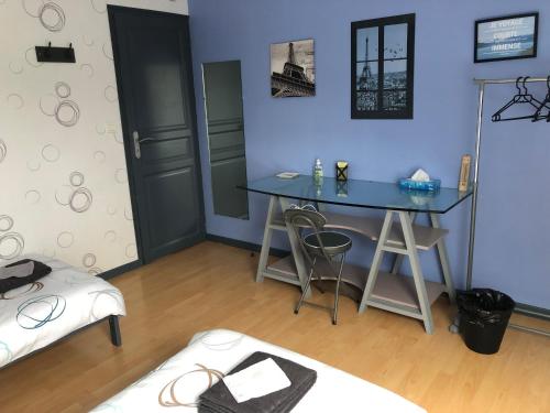 Cette chambre est dotée d'un mur bleu avec une table et des tabourets. dans l'établissement Chez Christophe et Cécile sur le circuit des 24 heures du Mans, à Arnage