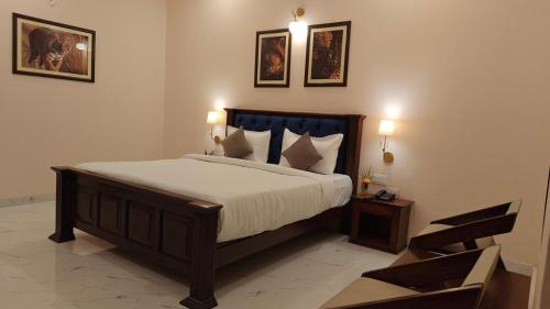 a bedroom with a large bed and two pictures on the wall at Sundervan Vilas Ranthambore in Khilchipur