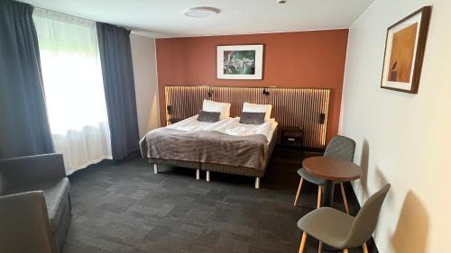 a hotel room with a bed and a table and chairs at Kompassen in Enköping