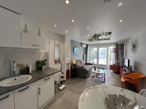 une cuisine et un salon avec un évier et une table dans l'établissement Port Frejus, 400m des plages et base nature, studi, à Fréjus