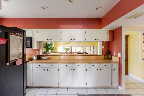 a large kitchen with white cabinets and red walls at Canterbury Oasis in Haines City
