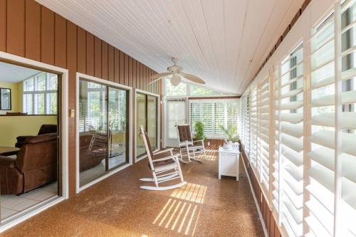 a screened in porch with a ceiling fan and chairs at Canterbury Oasis in Haines City