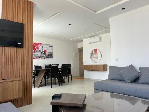 a living room with a couch and a dining room at RMILATE GARDEN N6 vue sur piscine in M'diq