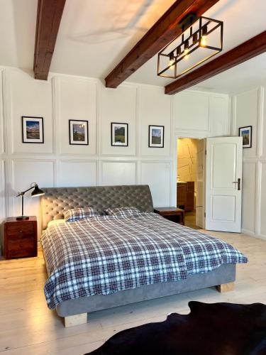 a bedroom with a bed in a room with white walls at Dworek Żabickie in Żabickie
