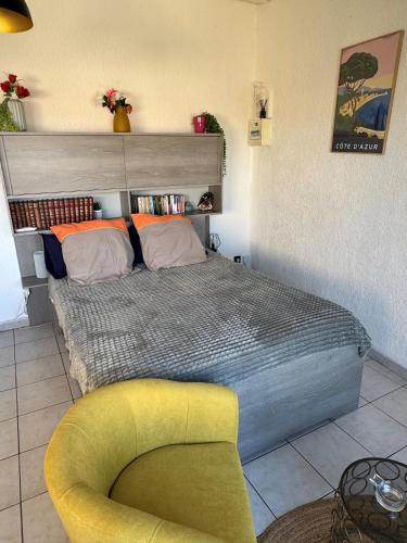 - une chambre avec un lit et une chaise jaune dans l'établissement Studio en Toit terrasse - Vue Mer - Grande Terrasse, à Toulon